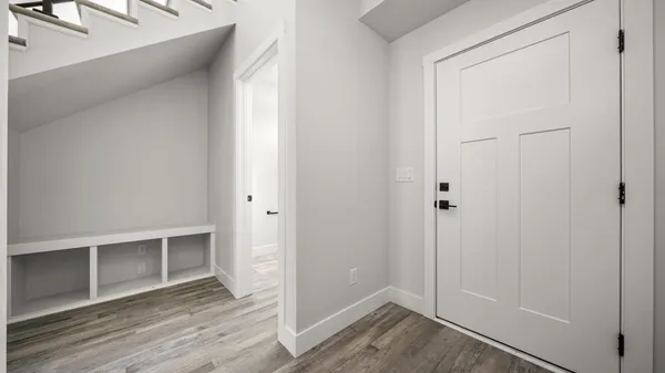 a view of an empty room with wooden floor and closet