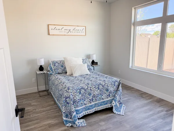 a view of an empty room with wooden floor and closet