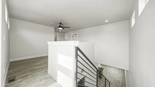 a view of a hallway with wooden floor and staircase