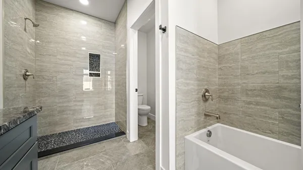 a bathroom with a granite countertop tub sink and mirror