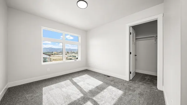 a view of a bedroom with wooden floor and window
