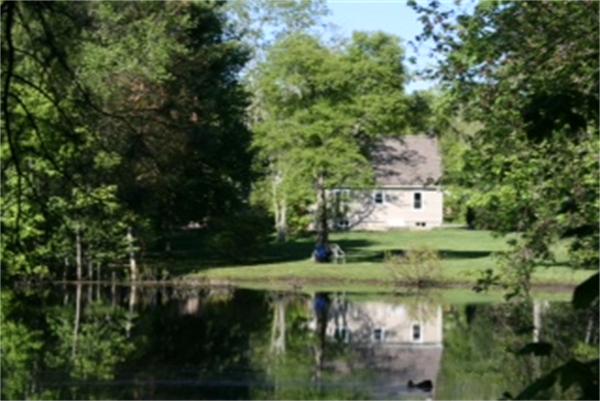 689 Walnut Plain Road Rochester, MA 02770 - Photo 2 of 22 a view of a lake with a house in background