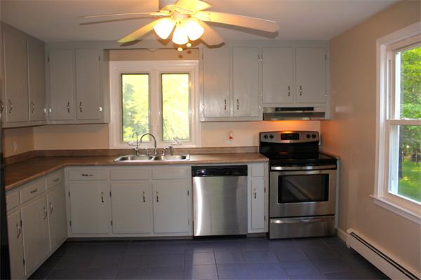 689 Walnut Plain Road Rochester, MA 02770 - Photo 7 of 22 a kitchen with stainless steel appliances a stove a sink and white cabinets