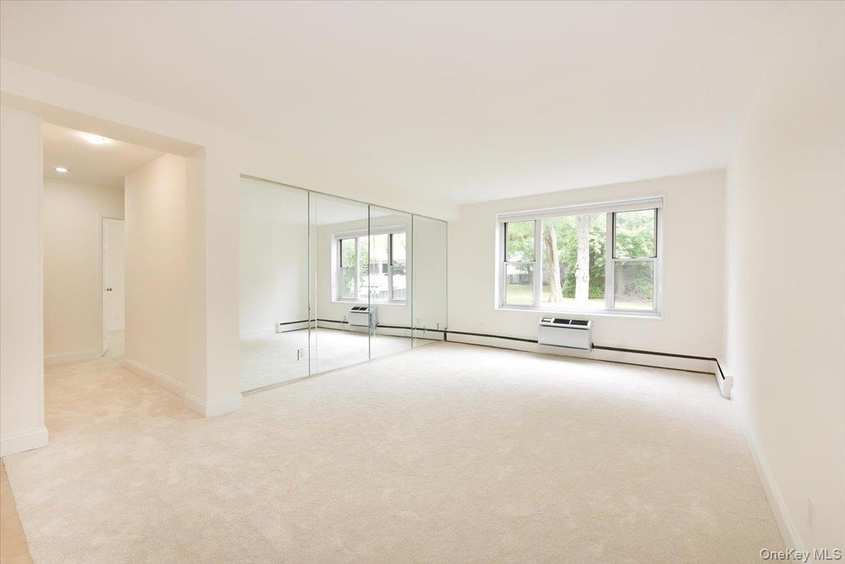 195 South Middle Neck Road, Unit 2L Great Neck, NY 11021 - Photo 2 of 36 an empty room with windows and view of kitchen