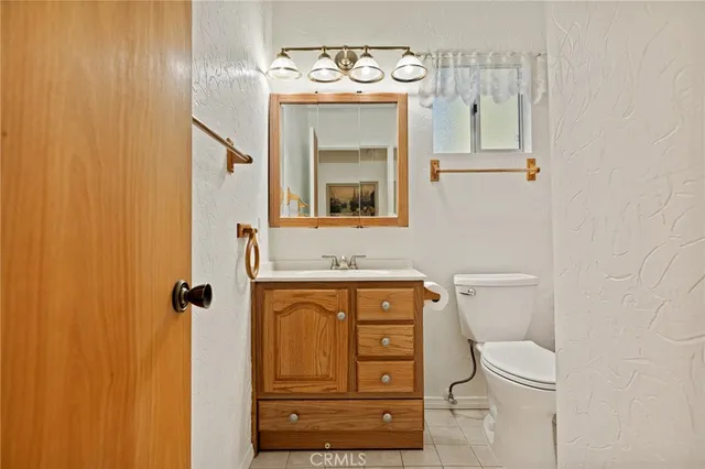 a bathroom with a toilet a sink and mirror