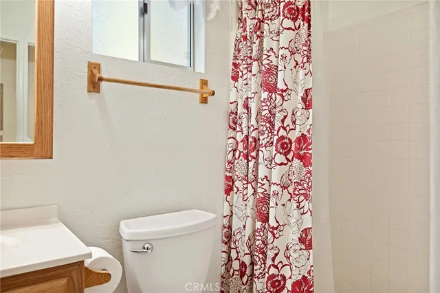 a white toilet sitting next to a shower curtain