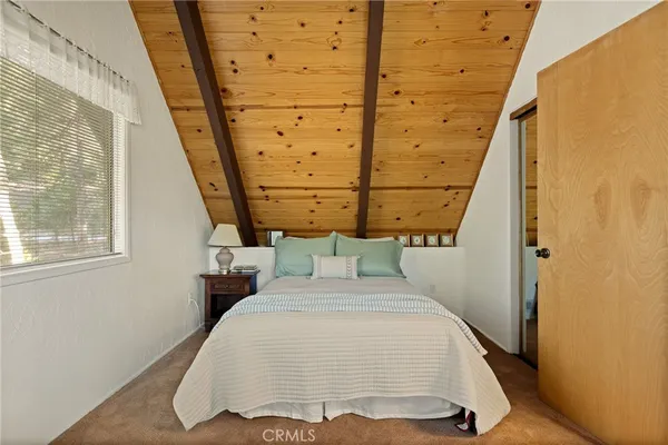 a bed sitting in a bedroom next to a window