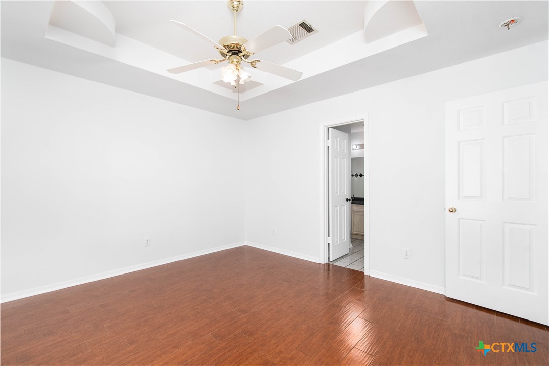 5420 Williams Drive Temple, TX 76502 - Photo 15 of 24 an empty room with a chandelier fan and wooden floor