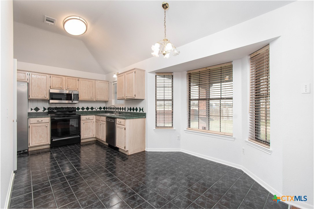 5420 Williams Drive Temple, TX 76502 - Photo 5 of 24 a kitchen with granite countertop a stove top oven a sink and dishwasher