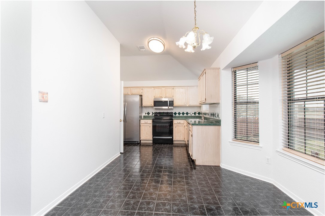 5420 Williams Drive Temple, TX 76502 - Photo 8 of 24 a view of a kitchen with a refrigerator a stove top oven and cabinets