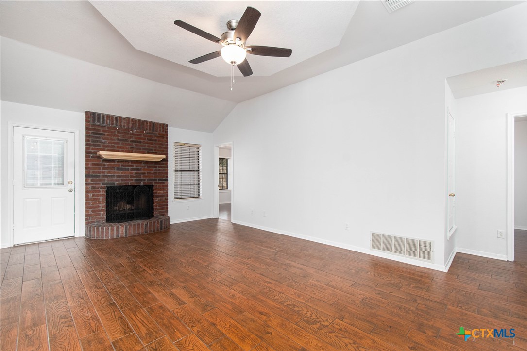 5420 Williams Drive Temple, TX 76502 - Photo 10 of 24 a view of an empty room with wooden floor fireplace and a window