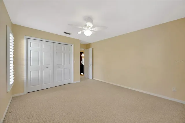 an empty room with a ceiling fan and a window