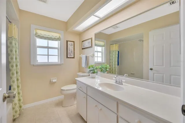 a bathroom with a double vanity sink toilet and a mirror