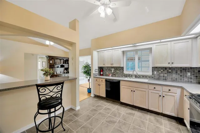 a kitchen with granite countertop a sink cabinets stainless steel appliances and a counter top space