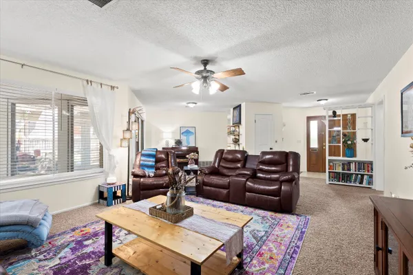 a living room with furniture a table and a large window