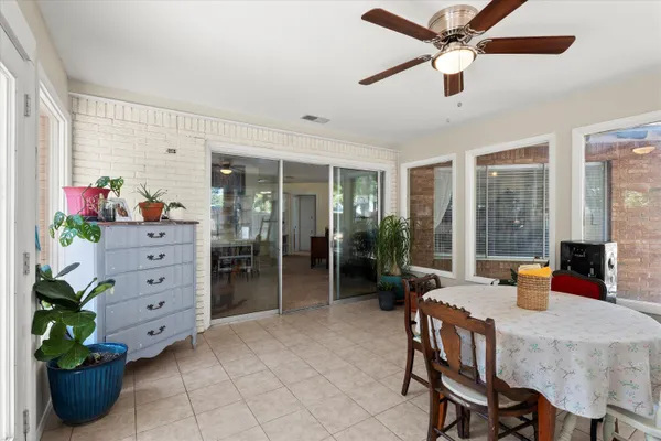 a dining room with furniture and potted plants