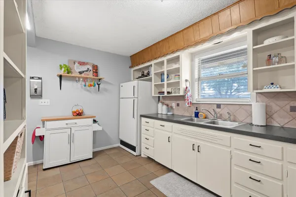 a kitchen with cabinets a window and appliances