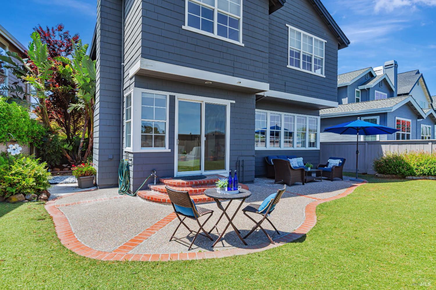 a view of a house with backyard sitting area and garden