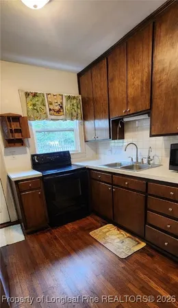 a kitchen with stainless steel appliances granite countertop wooden cabinets and a stove top oven
