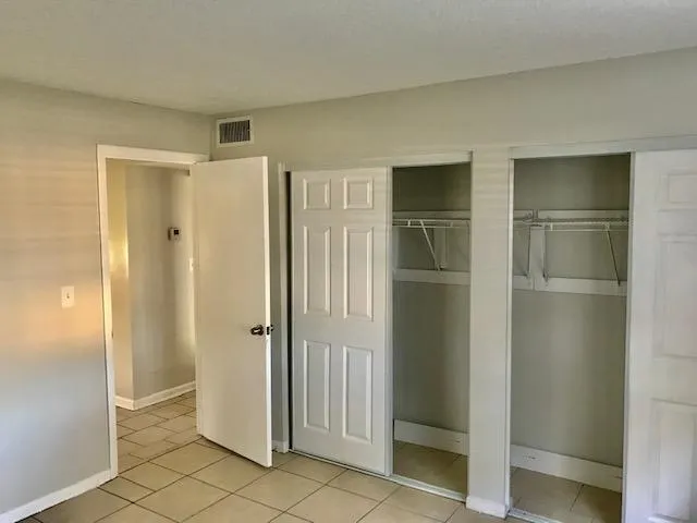 an empty room with windows and closet