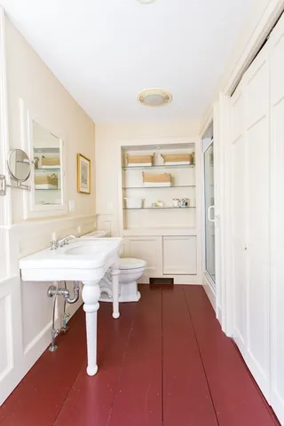 a bathroom with a sink a toilet and shower