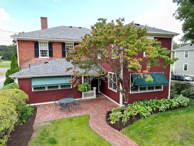 a front view of a house with a yard and green space
