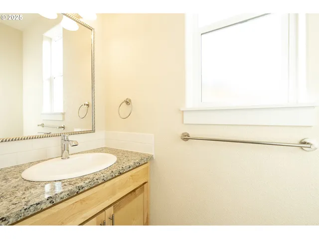 a bathroom with a granite countertop sink and a mirror