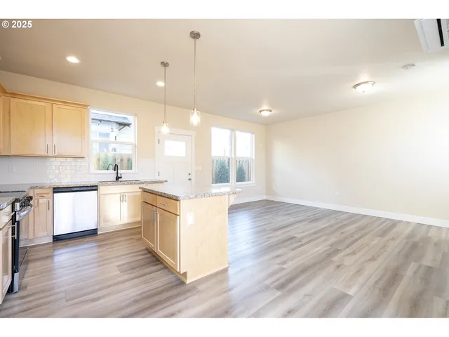 a large kitchen with cabinets wooden floor and stainless steel appliances