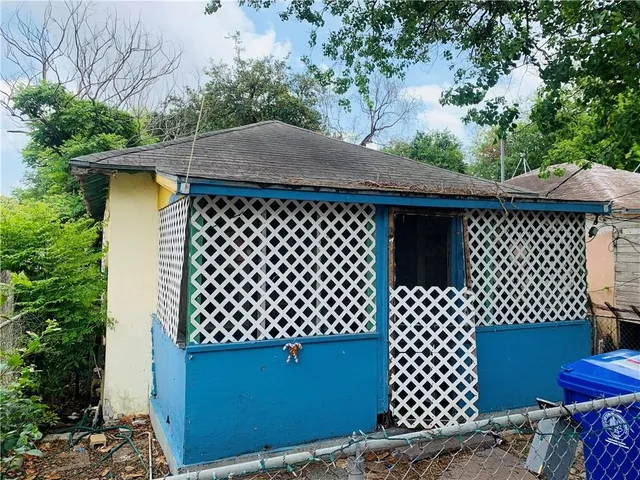 a view of a house with large tree and sitting area