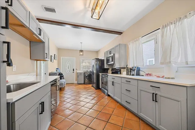a large kitchen with a sink and cabinets