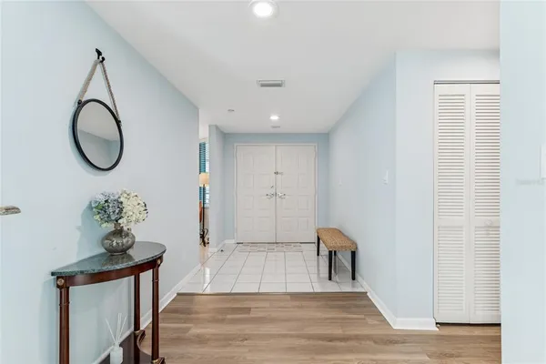 a room with chandelier fan and windows