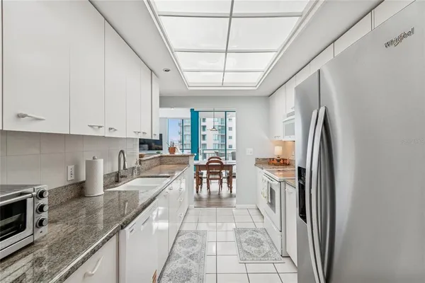 a kitchen with stainless steel appliances granite countertop a stove a sink and a refrigerator