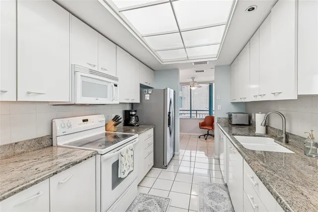 a kitchen with a sink a stove and cabinets