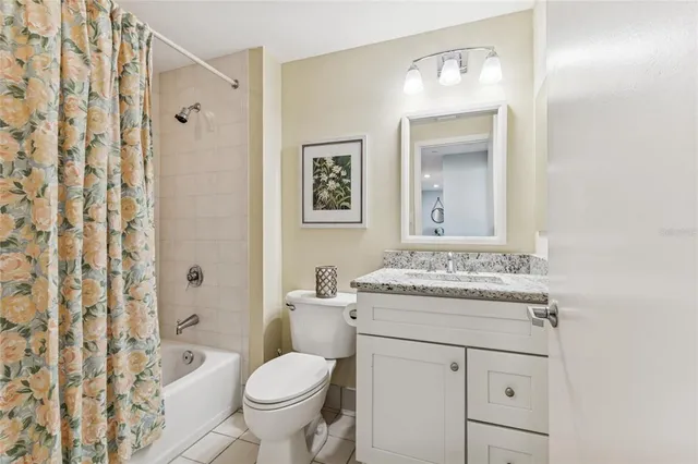 a bedroom with a bed and a lamp on dresser