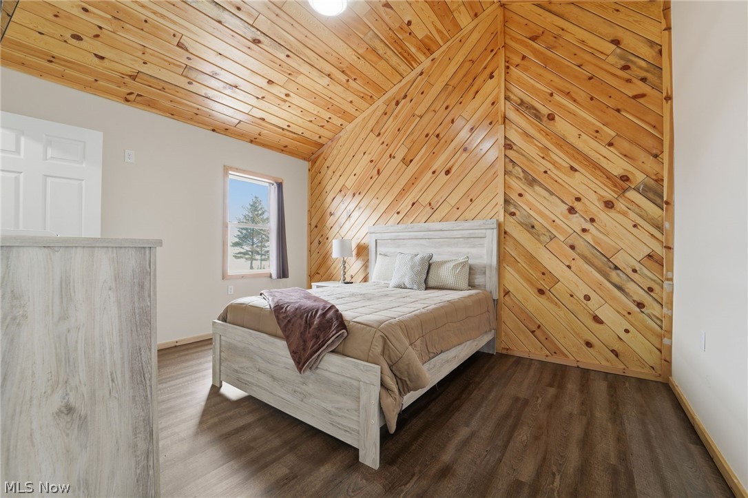 5919 Lake Road West, Unit 32 Ashtabula, OH 44004 - Photo 18 of 23 Bedroom featuring wood walls, wood finished floors, and a vaulted wood ceiling