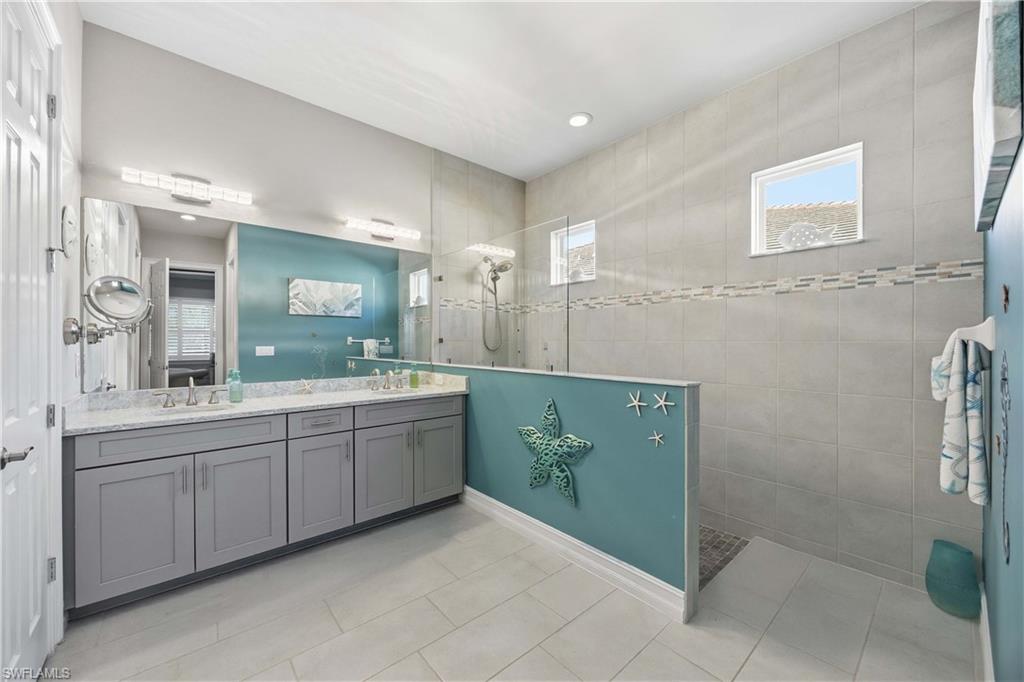 14748 Windward Lane Naples, FL 34114 - Photo 15 of 47 a spacious bathroom with a granite countertop sink a mirror and a