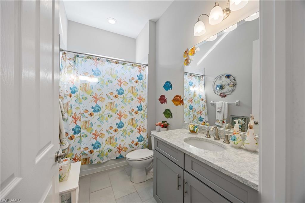 14748 Windward Lane Naples, FL 34114 - Photo 27 of 47 a bathroom with a sink a toilet and shower curtain