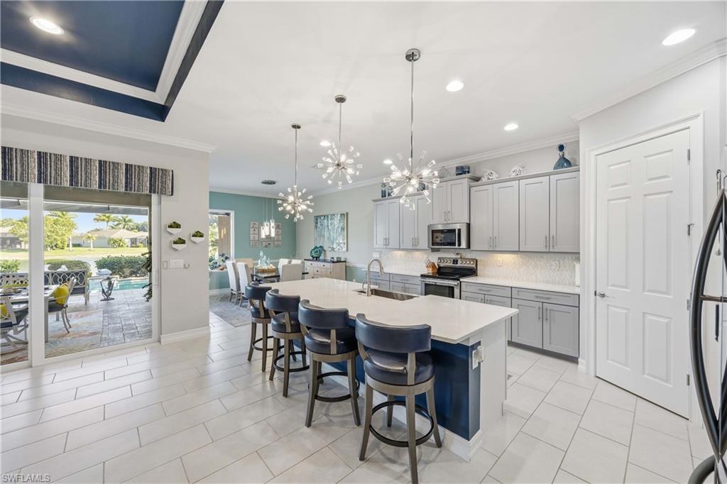 14748 Windward Lane Naples, FL 34114 - Photo 9 of 47 a large kitchen with a table and chairs