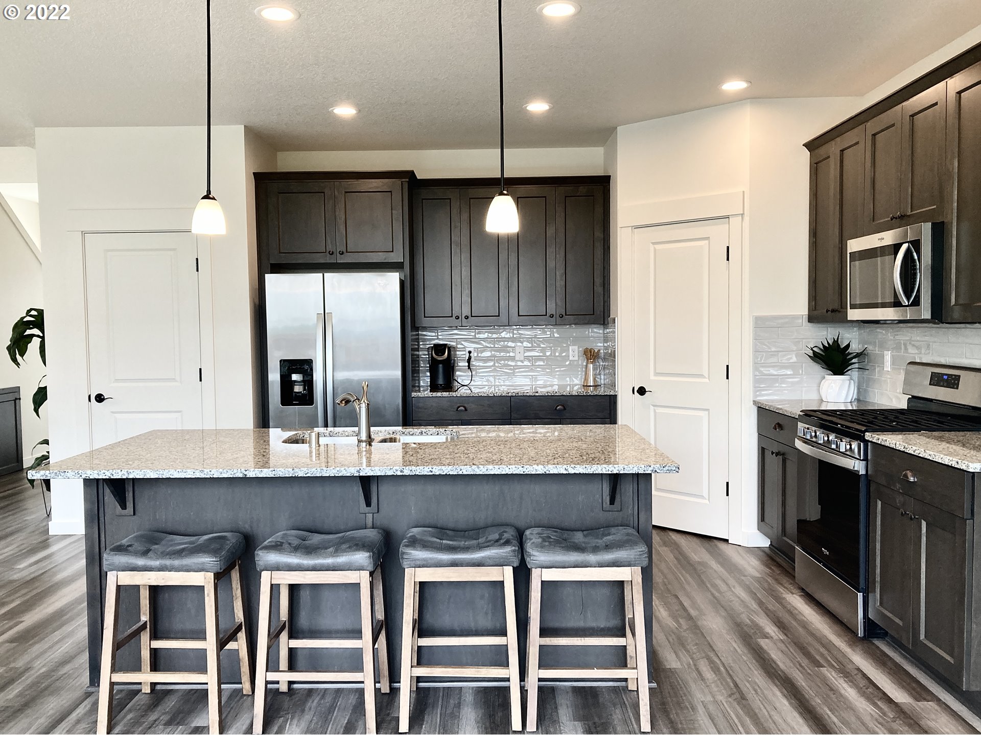 7138 South 11th Street Ridgefield, WA 98642 - Photo 6 of 14 a kitchen with kitchen island granite countertop a table chairs sink and stove top oven