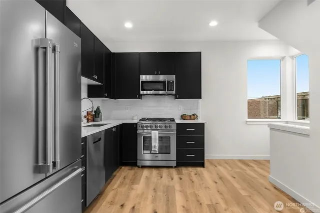 a kitchen with stainless steel appliances a stove a sink and a refrigerator