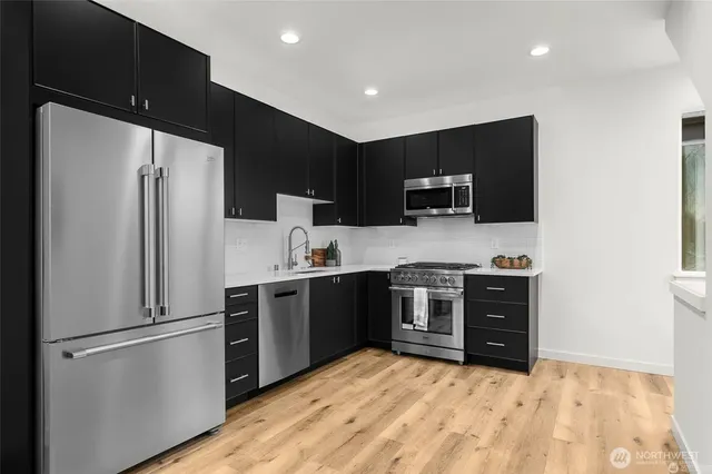 a kitchen with a refrigerator and a stove top oven