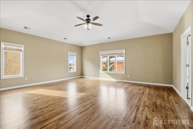 a view of an empty room and window with wooden floor