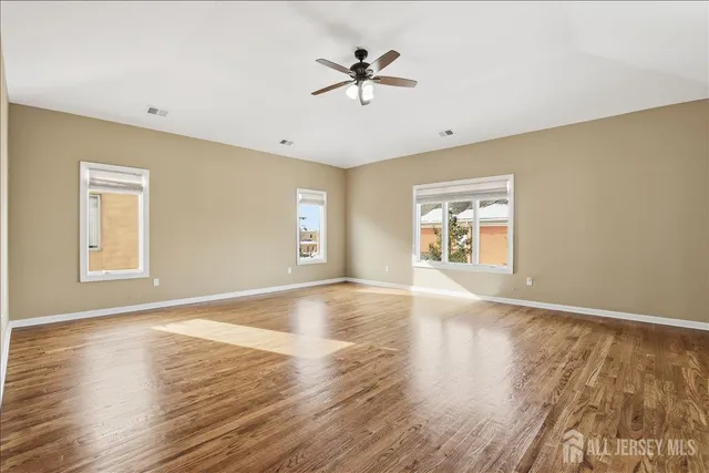 a spacious bathroom with a granite countertop double vanity sink a mirror and a bathtub
