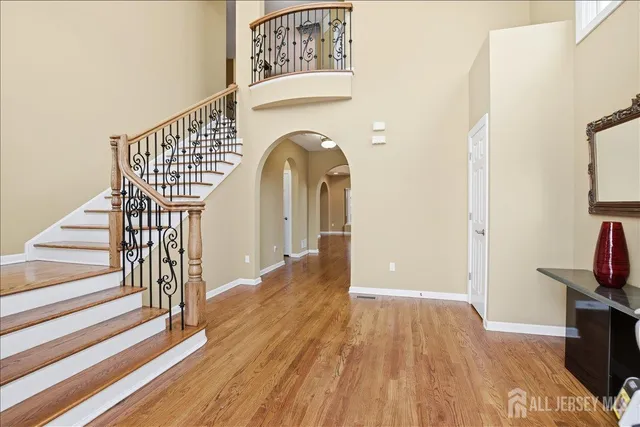 a view of a hallway with wooden floor and staircase