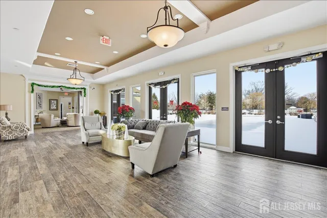 a spacious bedroom with a bed a dresser and wooden floor