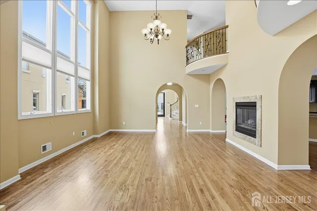 a view of a hallway with wooden floor and a kitchen
