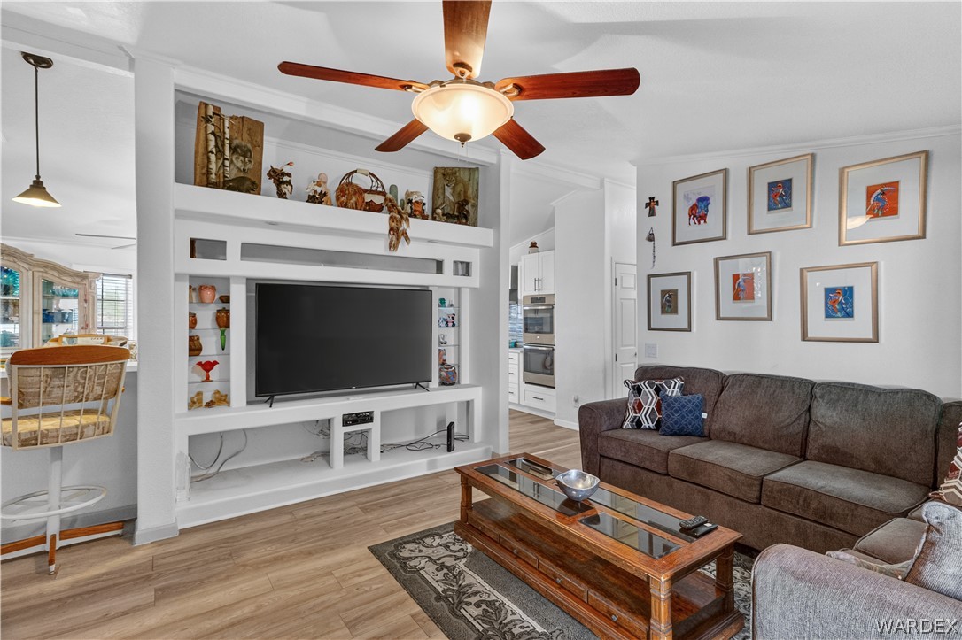 784 Pegasus Ranch Road Bullhead City, AZ 86429 - Photo 21 of 100 Living area featuring wood-finish flooring and a built-in entertainment center with open shelving