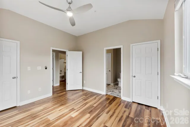 a view of empty room with wooden floor and ceiling fan