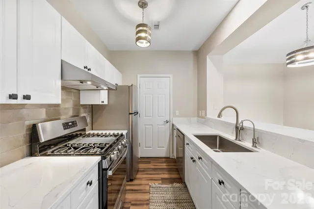 a kitchen with a sink stove top oven and cabinets