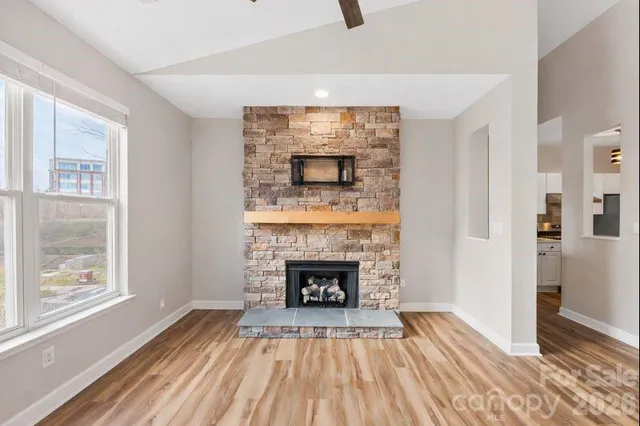 a living room with a fireplace and wooden floor